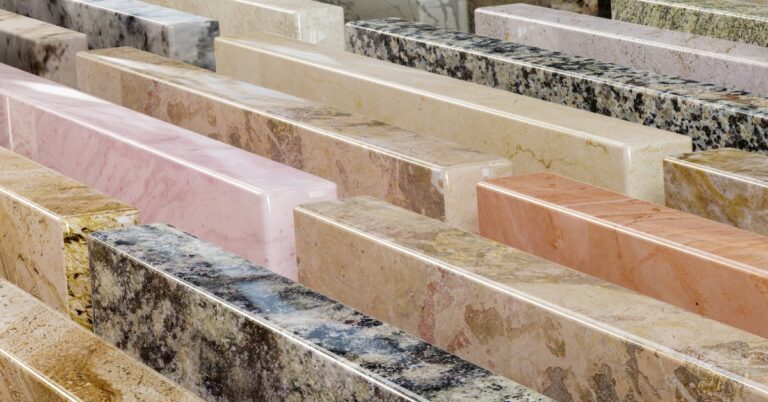 A close-up of a display of various quartz countertop colors, ranging from pink to orange to black and more.