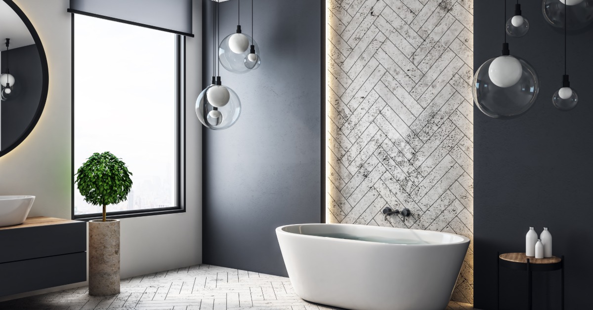 A modern bathroom with a double-vanity sink, mirrors, a bathtub, marble tiling on the wall and decorative floor tiling.