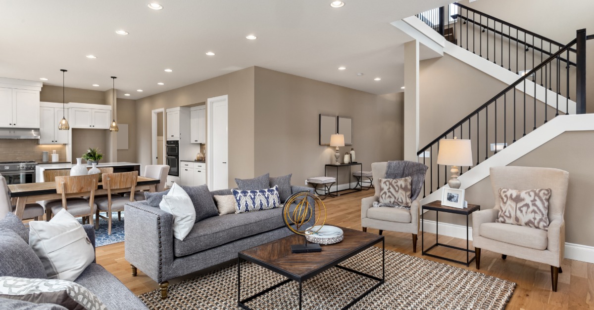 The first floor of a home with an open floor plan that includes a living room, dining table, and kitchen.