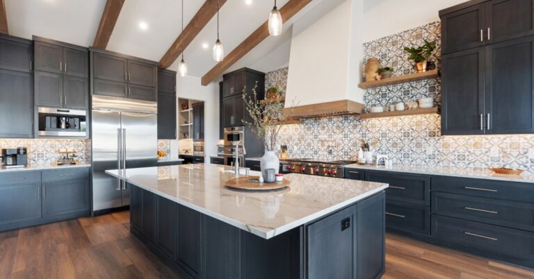 An open-floor kitchen in a modern home with white quartz countertops, a large kitchen island, and navy cabinetry.