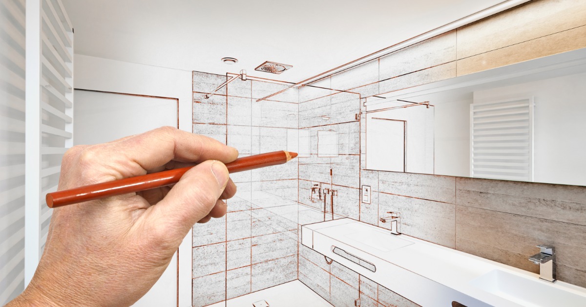 A hand holding a pencil to draw a bathroom design that gradients into a photograph of the finished bathroom.