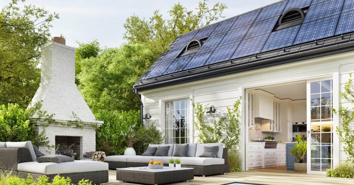 The backyard of a home with a large patio, outdoor furniture, an outdoor fireplace, a pool, and solar panels on the roof.