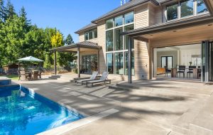 Luxury home exterior and pool on sunny day with blue sky