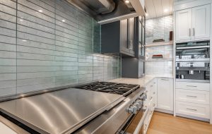 Luxurious high end kitchen with stainless appliances marble and glass tile