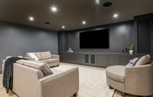 interior media room with dark grey walls comfortable furniture and large tv screen